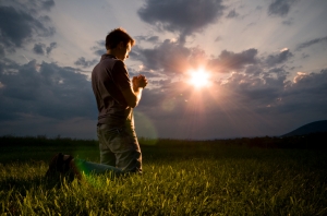 man praying in field